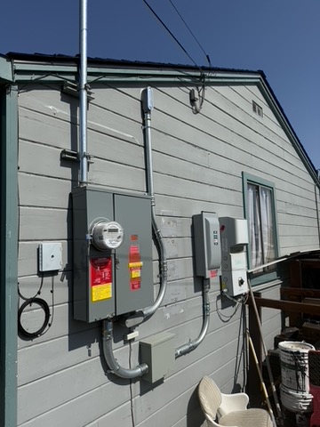 Meter, disconnects and conduit along an exterior wall.